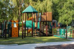 colorful playground equipment with green trees in the background